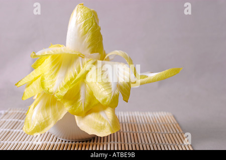 Le cicorie di Bruxelles sul tappetino di bambù Foto Stock