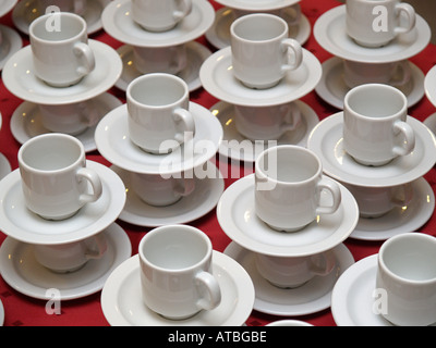 Pattern vuoti di tazze da caffè in attesa di essere riempita su tavola con tovaglia rossa Foto Stock