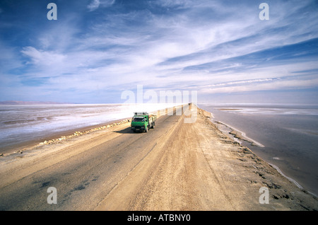 Un carrello di guida su una sezione di 90km lungo la strada rialzata che attraversa il Chott el Jerid più grande dei laghi di sale nel sud della Tunisia centrale gateway per le terre del deserto Foto Stock