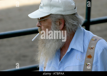 Uomo anziano avente una sigaretta al rodeo Foto Stock