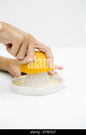 La donna a spremere il succo arancia, vista ritagliata, close-up Foto Stock