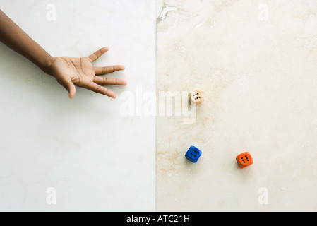 Bambino gettando dadi, vista ritagliata della mano Foto Stock