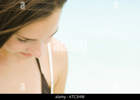 Giovane donna all'aperto, guardando verso il basso, close-up Foto Stock