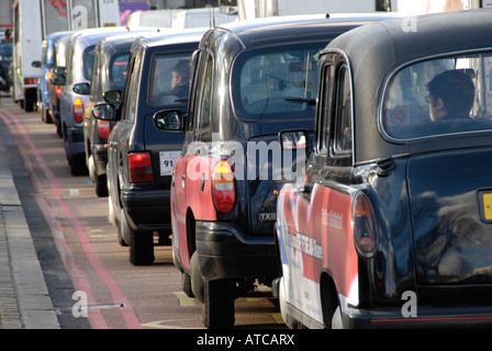 Coda di nero Londra taxi nel traffico Foto Stock