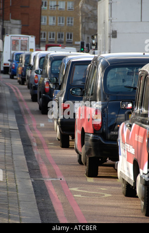 Coda di nero Londra taxi nel traffico Foto Stock