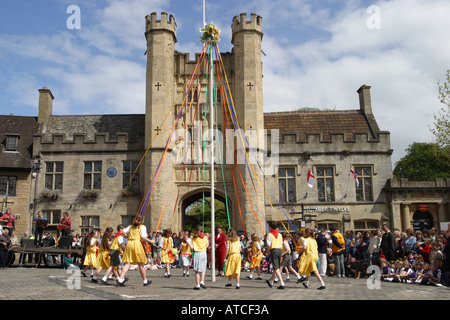 Wells Somerset i bambini danza attorno al palo può durante il ballo tradizionale in pozzetti Luogo di mercato con i Vescovi torre degli occhi Foto Stock