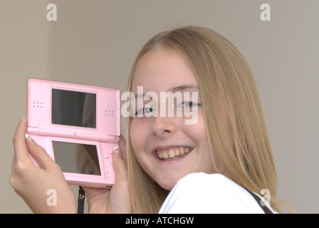 Giovane ragazza tenendo un Nintendo DS lite console di gioco UK Foto Stock