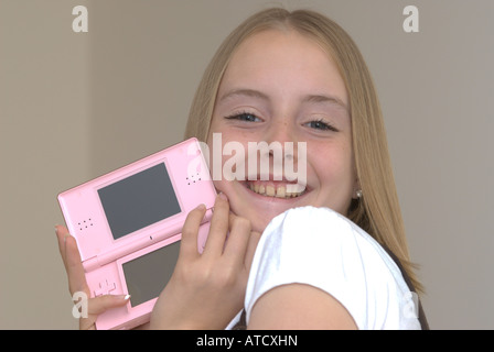 Giovane ragazza tenendo un Nintendo DS lite console di gioco UK Foto Stock