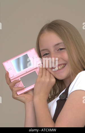 Giovane ragazza tenendo un Nintendo DS lite console di gioco UK Foto Stock