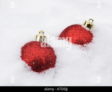 two christmas baubles in white snow Foto Stock