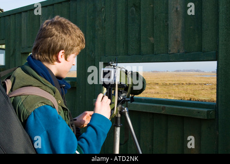 Osservazione degli uccelli, vestito di verde, con ambito di applicazione con ambito treppiede e adattatore fotocamera a Sandside Southport Merseyside Foto Stock