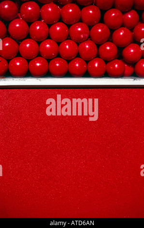 Un rosso gumball macchina riempita di rosso le palle di gomma Foto Stock