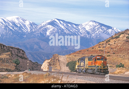 Due motori BNSF 6804 e 6364 riportando la luce verso il basso il Cajon Pass in California del sud Foto Stock