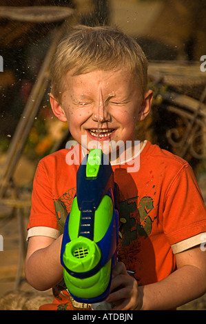 Boy squirting viso con acqua Foto Stock