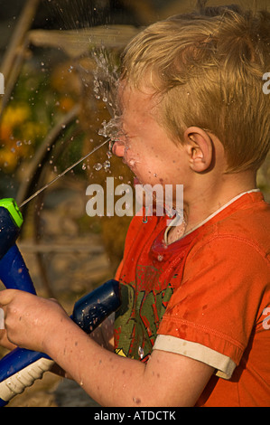 Boy squirting viso con acqua Foto Stock