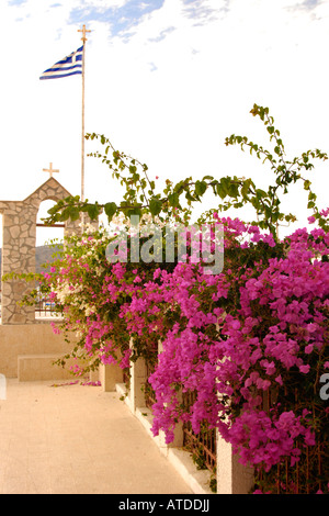 Bouganville e bandiera greca sull isola di Lipsi, isole Dodecanesi, Grecia Foto Stock