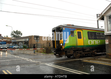 Un treno passeggeri andando oltre il passaggio a livello Stowmarket Suffolk East Anglia Foto Stock