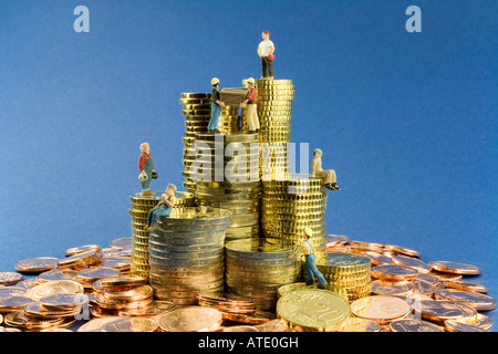 Costruzione di lavoratore figure su cumuli di denaro e denaro pile Foto Stock