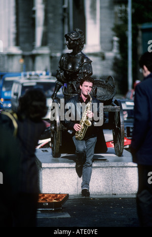 Ritratto di Busker suonare il sassofono nella parte anteriore del Molly Malone statua Dublino Irlanda Foto Stock