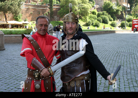 Due uomini vestiti come centurioni romani in posa per i turisti a Roma Italia Foto Stock