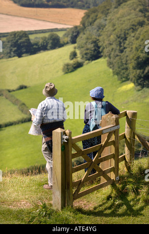 Una coppia di escursionisti PRENDERE IN VISTA DEL GLOUCESTERSHIRE REGNO UNITO DA ULEY BURY A DOWNHAM HILL conosciuto localmente come il vaiolo HILL A CAUSA ONC Foto Stock