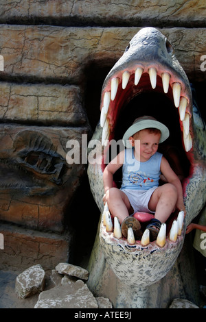 Tema Dinosaur Park, sede del capretto nella bocca del dinosauro Foto Stock