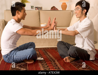 Profilo laterale di due giovani uomini che danno alta cinque Foto Stock