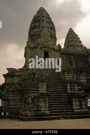 Grande enorme imprimendo imponenti massicci scoscesi pietra indù TEMPIO PIRAMIDE & uomini siedono fondo Angkor Wat Cambogia del Sud-est asiatico Foto Stock