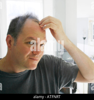 Uomo di controllo specchietto assottigliamento dei capelli Foto Stock