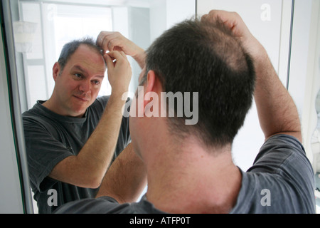 Controllo dell'uomo calvo patch in specchio Foto Stock