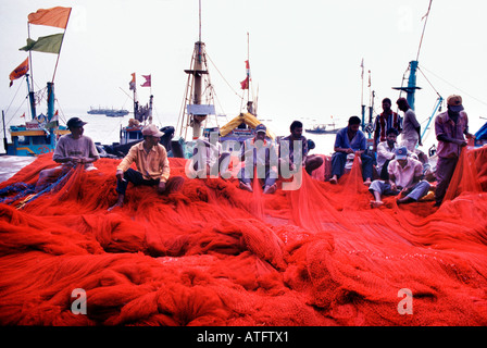 Kohli pescatori riassettavano le reti a Sassoon (Sassun) Docks Colaba il pesce principale di carico e di centro di scambi commerciali nel sud di Mumbai, India. Foto Stock