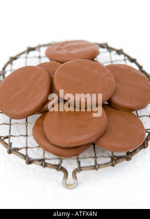 Pila di organico ricoperta di cioccolato biscotti allo zenzero - presentato su un filo vintage raffreddamento per rack Foto Stock