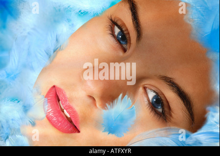 Volto di giovane donna in blu di piume Foto Stock