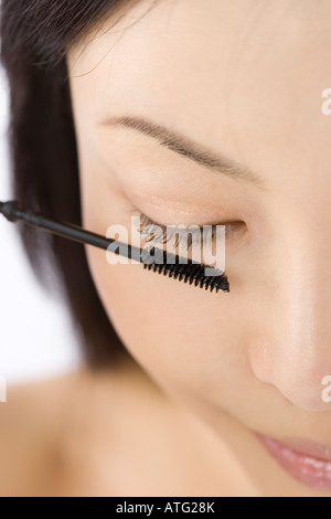 Giovane donna applicazione di mascara Foto Stock
