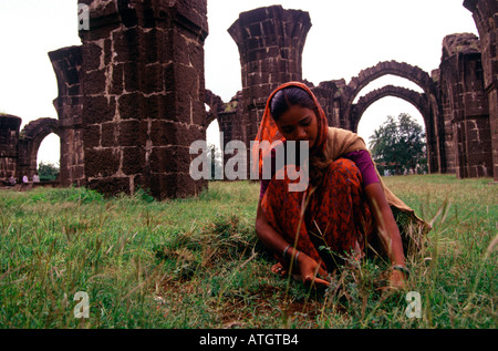 Una giovane donna tra le rovine di Bara Kaman un incompiuto mausoleo di Ali Adil Shah II a Bijapur ufficialmente conosciuto Come Vijayapur nello stato di Karnataka India Foto Stock