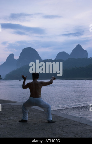 L'uomo praticare il Tai Chi all'alba, Yangshuo, Guangxi, Cina Foto Stock