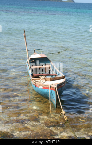 Una barca da pesca galleggia sopra le acque chiare del Cayos Cochinos (isole di porco), Honduras, off il paese della costa caraibica. Foto Stock