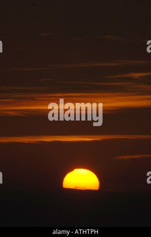 Il sole che tramonta dietro le nuvole. Foto Stock