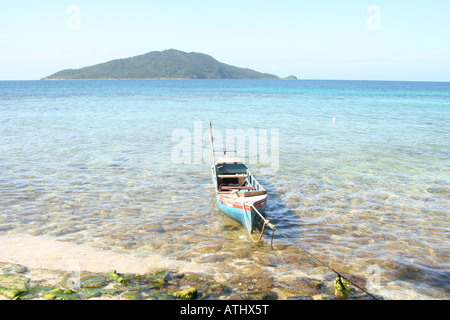 Una barca da pesca galleggia sopra le acque chiare del Cayos Cochinos (isole di porco), Honduras, off il paese della costa caraibica. Foto Stock