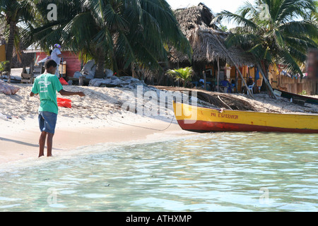 Un ragazzo pesci in Chachahuate in Cayos Cochinos (isole di porco), Honduras, un villaggio Garifuna off il paese della costa caraibica Foto Stock