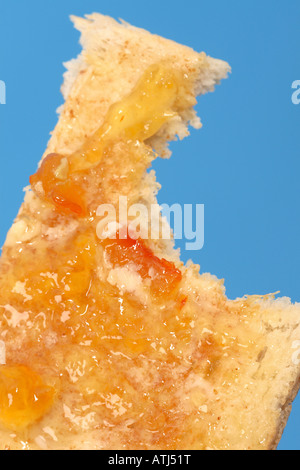 La colazione fetta di pane tostato con marmellata di arance e burro e mordere mark Foto Stock