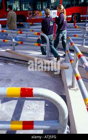 Due giovani donne vestite in modo identico a piedi attraverso un sentiero pedonale diversione in strada Foto Stock