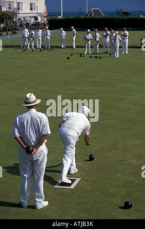 Maschio team bowling in ingranaggio bianco giocando a Bognor Regis bowling green Inghilterra Foto Stock