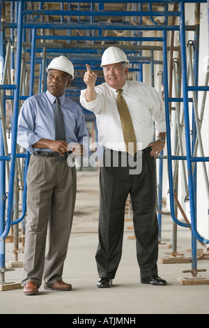 Due ingegneri discutendo in corrispondenza di un sito in costruzione Foto Stock