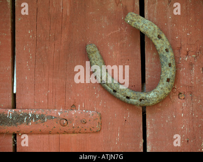 Il ferro di cavallo come simbolo per fortuna sulla porta chiusa di un capannone di registro Foto Stock