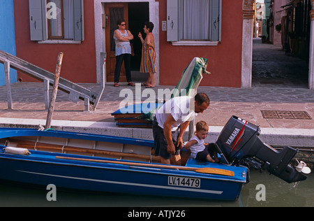 Uomo con figlio sulla barca in canale. Murano, Venezia. Foto Stock