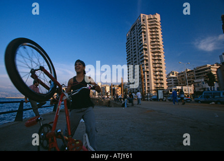 Ragazzo adolescente facendo stunt in bicicletta sul lungomare Corniche, Beirut, Libano Foto Stock