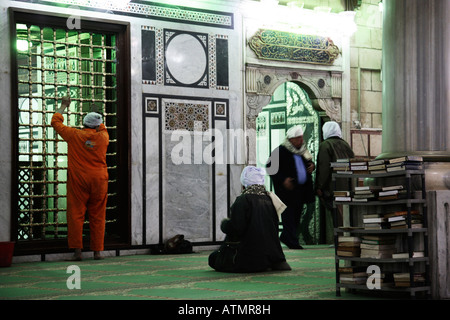 All'interno della moschea di Sayedna el-Husseyn uomini di preghiera mentre un uomo è la pulizia. Foto Stock