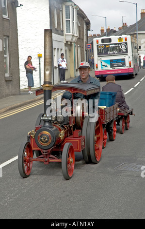 Un uomo alla guida di un modello in scala con trazione a vapore il motore attraverso le strade di camborne,cornwall,su Richard Trevithick giorno. Foto Stock