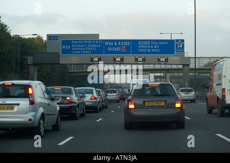 Vetture con lampeggiamento delle luci di segnalazione pericolo in coda di traffico su M56 AUTOSTRADA Foto Stock